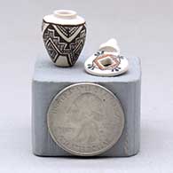 A miniature black on white jar decorated with an ancient Mogollon geometric design and with a cutout in the lid, click or tap to see a larger version