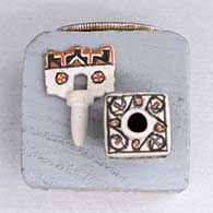 A miniature polychrome square jar decorated with a geometric design and a tablito lid, click or tap to see a larger version