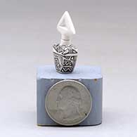 A miniature black on white lidded rectangular jar with a cutout in the lid and and decorated with a fineline and geometric design, click or tap to see a larger version