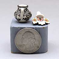 A miniature black on white jar with handles and a polychrome tablito lid and and decorated with a fineline, checkerboard and geometric design, click or tap to see a larger version