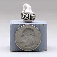 A miniature black on white pitcher with a handle and decorated with a geometric design, click or tap to see a larger version
