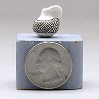 A miniature black on white pitcher with a handle and decorated with a geometric design, click or tap to see a larger version