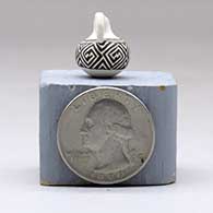 A miniature black on white pitcher with a handle and decorated with a geometric design, click or tap to see a larger version
