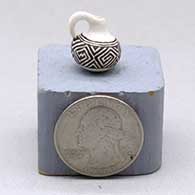 A miniature black on white pitcher with a handle and decorated with a geometric design
 by Thomas Natseway of Laguna