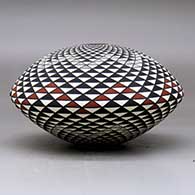 A polychrome seed pot decorated with a spiral mesa geometric design, click or tap to see a larger version