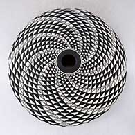A black on white seed pot decorated with a spiral mesa geometric design, click or tap to see a larger version