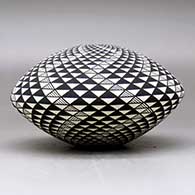 A black on white seed pot decorated with a spiral mesa geometric design, click or tap to see a larger version