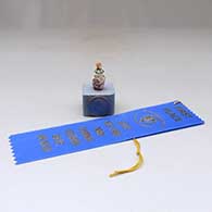A lidded, polychrome miniature square jar with a flower-sculpted lid and flower design, First Place ribbon from the Gallup InterTribal Ceremonial
 by Thomas Natseway of Laguna