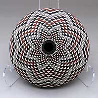 A polychrome seed pot decorated with a spiral mesa geometric design top and bottom
 by Robert Kasero Sr of Laguna