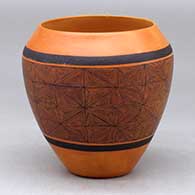 A black on red jar decorated around the body with a snowflake fineline geometric design
 by Calvin Analla Jr of Laguna