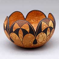 A black on mixed clay bowl with a six-petal scalloped rim and decorated with a fineline and geometric design
 by Calvin Analla Jr of Laguna