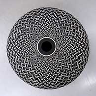 A black on white seed pot decorated with a spiraling geometric design
 by Robert Kasero Sr of Laguna