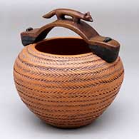 There is a fox on the wooden handle of this brown jar decorated with bands of sgraffito design
 by Richard Zane Smith of Wyandot