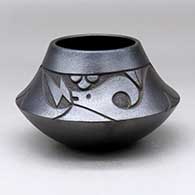 A micaceous black jar decorated with a lightly-carved avanyu and geometric design above the shoulder
 by Robert Vigil of Nambe