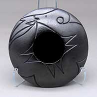 A micaceous black seed pot decorated with a lightly carved avanyu and geometric design above the shoulder
 by Robert Vigil of Nambe