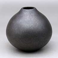 A black micaceous jar with a small, raised opening
 by Robert Vigil of Nambe