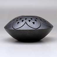 A black micaceous jar decorated with a lightly carved geometric design and a corrugated geometric design above the shoulder, click or tap to see a larger version