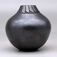 A black micaceous jar decorated with a lightly carved band of feathers around the neck, click or tap to see a larger version