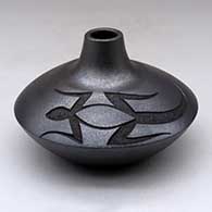 Click for a larger view A micaceous black jar with a small neck and opening and decorated with a sgraffito lizard design above the shoulder
by Robert Vigil of Nambe