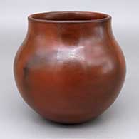 A plain, polished brown jar coated with pinon pitch and decorated with fire clouds
 by Susie Crank of Dineh