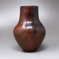 A polished brown vase with fire clouds and a pine pitch coating, click or tap to see a larger version