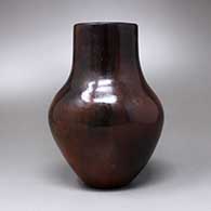 A polished brown vase with fire clouds and a pine pitch coating, click or tap to see a larger version