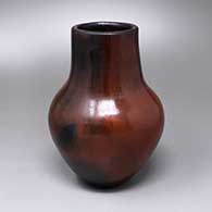 A polished brown vase with fire clouds and a pine pitch coating
 by Alice Cling of Dineh