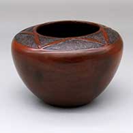 A brown jar with a sgraffito geometric design above the shoulder
 by Sue Ann Williams of Dineh