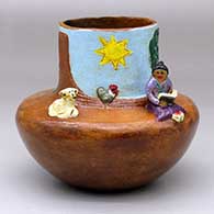 A polychrome Navajo Lifestyle pot with a sitting woman reading, with dog and sheep appliques
 by Elizabeth Manygoats of Dineh