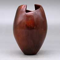 A polished brown jar with a geometric cut opening and decorated with fire clouds, click or tap to see a larger version