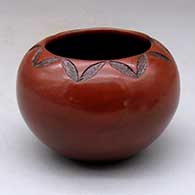 A brown bowl decorated with a sgraffito geometric design around the opening and fire clouds
 by Sue Williams of Dineh
