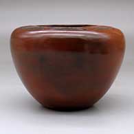 A brown jar with a flat top decorated with a sgraffito geometric design above the shoulder and fire clouds, click or tap to see a larger version