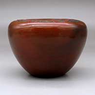 A brown jar with a flat top decorated with a sgraffito geometric design above the shoulder and fire clouds, click or tap to see a larger version