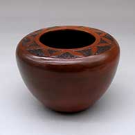 A brown jar with a flat top decorated with a sgraffito geometric design above the shoulder and fire clouds
 by Sue Williams of Dineh