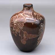 A squarish brown jar with a sgraffito birds, vines, flowers and leaves design
 by Bernice Naranjo of Taos