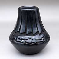 A low-shouldered black jar carved with a ring of feathers and avanyu design
 by Chris Martinez of Santa Clara