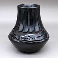 A low-shouldered black jar carved with a ring of feathers and avanyu design
 by Chris Martinez of Santa Clara
