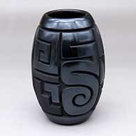 A black jar carved with a bear, spiral, kiva step and geometric design in polished black and matte black
 by Harrison Begay Jr of Santa Clara