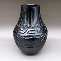 A large black jar carved with a scrolls, feathers and avanyu geometric design
 by Mary Singer of Santa Clara