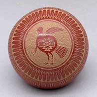 A miniature red seed pot decorated with a a sgraffito turkey, feather, scroll, avanyu, katsina and geometric design
 by Joseph Lonewolf of Santa Clara