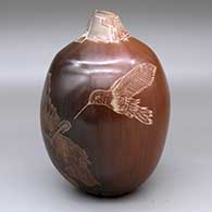 A brown jar decorated with a sgraffito hummingbird, flower and geometric design
 by Bernice Naranjo of Taos