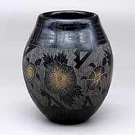 A black jar with sienna spots and decorated with a four-panel sgraffito turtle, flower and geometric design
 by Melvin Moquino of Santa Clara