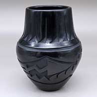 A black jar with an avanyu and geometric design carved around the shoulder plus a feather design carved around the neck
 by Sherry Tafoya of Santa Clara