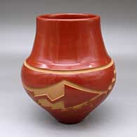 A red jar with an avanyu and geometric design carved around the shoulder
 by Sherry Tafoya of Santa Clara