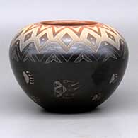 A black bowl with a sienna rim, decorated with a sgraffito bear paw and geometric design
 by Justin Naranjo of Santa Clara