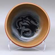 A red, sienna and black bowl carved inside with an avanyu design
 by Sharon Naranjo Garcia of Santa Clara