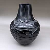 A large black jar carved with an avanyu, feathers, clouds and geometric design
 by Elizabeth Naranjo of Santa Clara