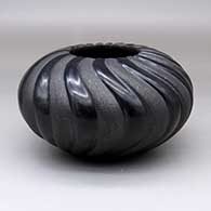 A black melon jar carved with 24 ribs, alternating ribs decorated with micaceous clay
 by Linda Tafoya of Santa Clara