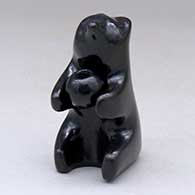 A sitting black bear figure holding a pot
 by Jarren Naranjo of Santa Clara