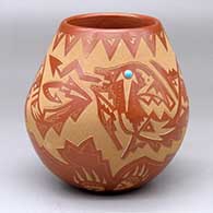 A red jar decorated with a sgraffito avanyu, bear paw and geometric design, plus an inlaid stone
 by Sammy Naranjo of Santa Clara